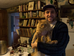 Owner and operator of The Barking Kettle is holding his cat, Douglas, who helps him forage food.