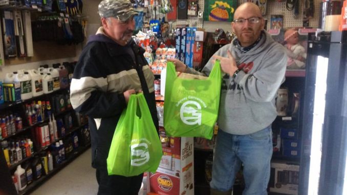 Randy Holwell (left) and Peter Dyson holds re-usable shopping bags at Gateway Convenience. 