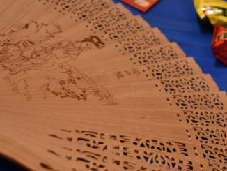 A Chinese wooden fan, candy and red envelopes.