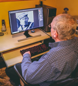 Gerard Nash restoring a photo of a Navy officer in his home in St. John's.