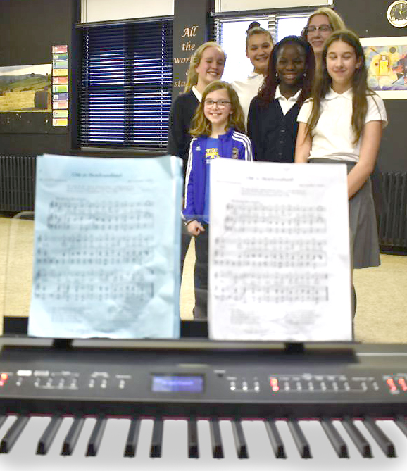 Angela Warren's music students pose before the piano for a photograph after their interviews. 
