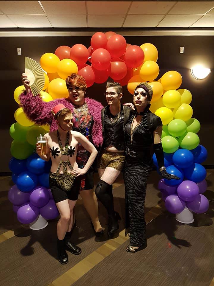 Drag performers from pose under the balloon umbrella at Queer Prom. From left to right, Johnny Diamond, Evelyn J Tudor, Dr. Androbox, and Fashionista Jones.