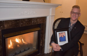 Hubert Locke's nephew, Grant Janes-Locke, holds a photograph of his uncle. Janes-Locke is a funeral director who will be directing at his uncle's funeral. 