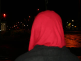a woman wearinga red hijab looks down PPD sidewalks