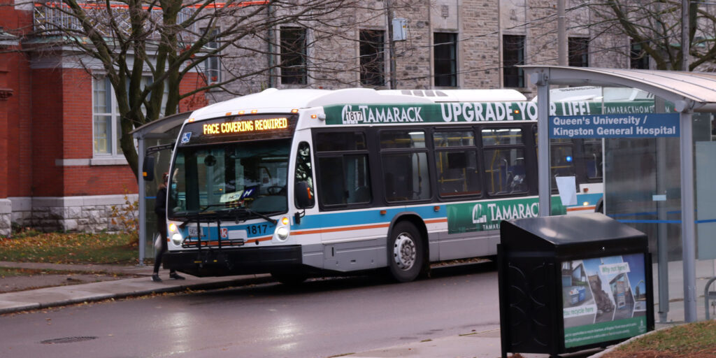 Photo depicts a woman boarding a city bus downtown Kingston