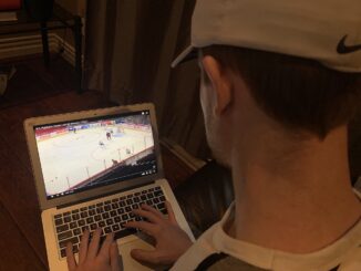 Person watches NHL on laptop