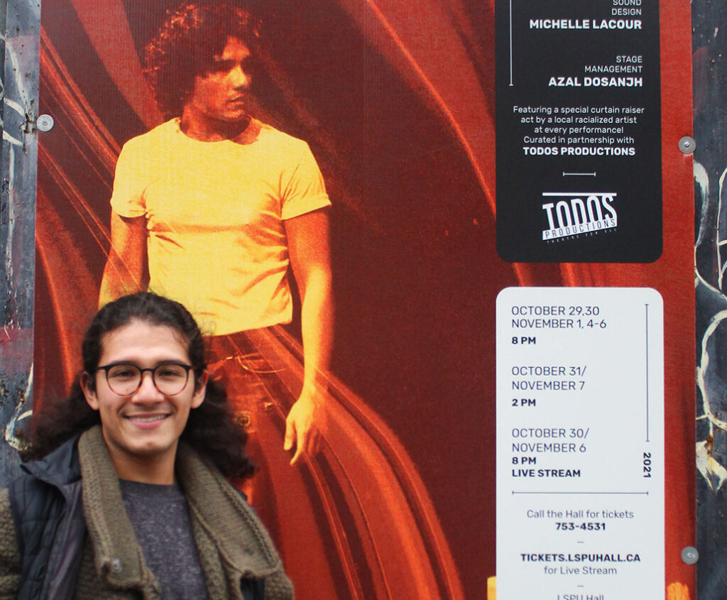 Santiago Guzmán, playwright and performer of ALTAR stands in front of a sign featuring the show. 
