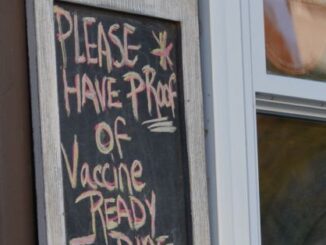 proof-of-vaccine required sign on wall at restaurant
