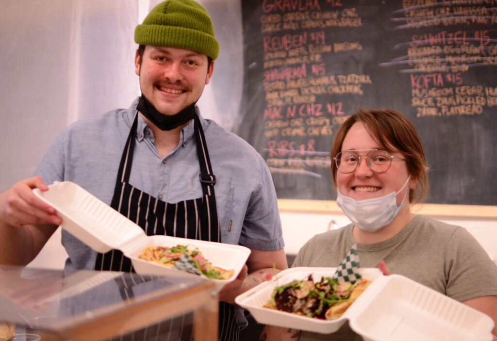 Conor O'Brien and Stephanie Mauger pose with food plates from Crumb+Pickle.