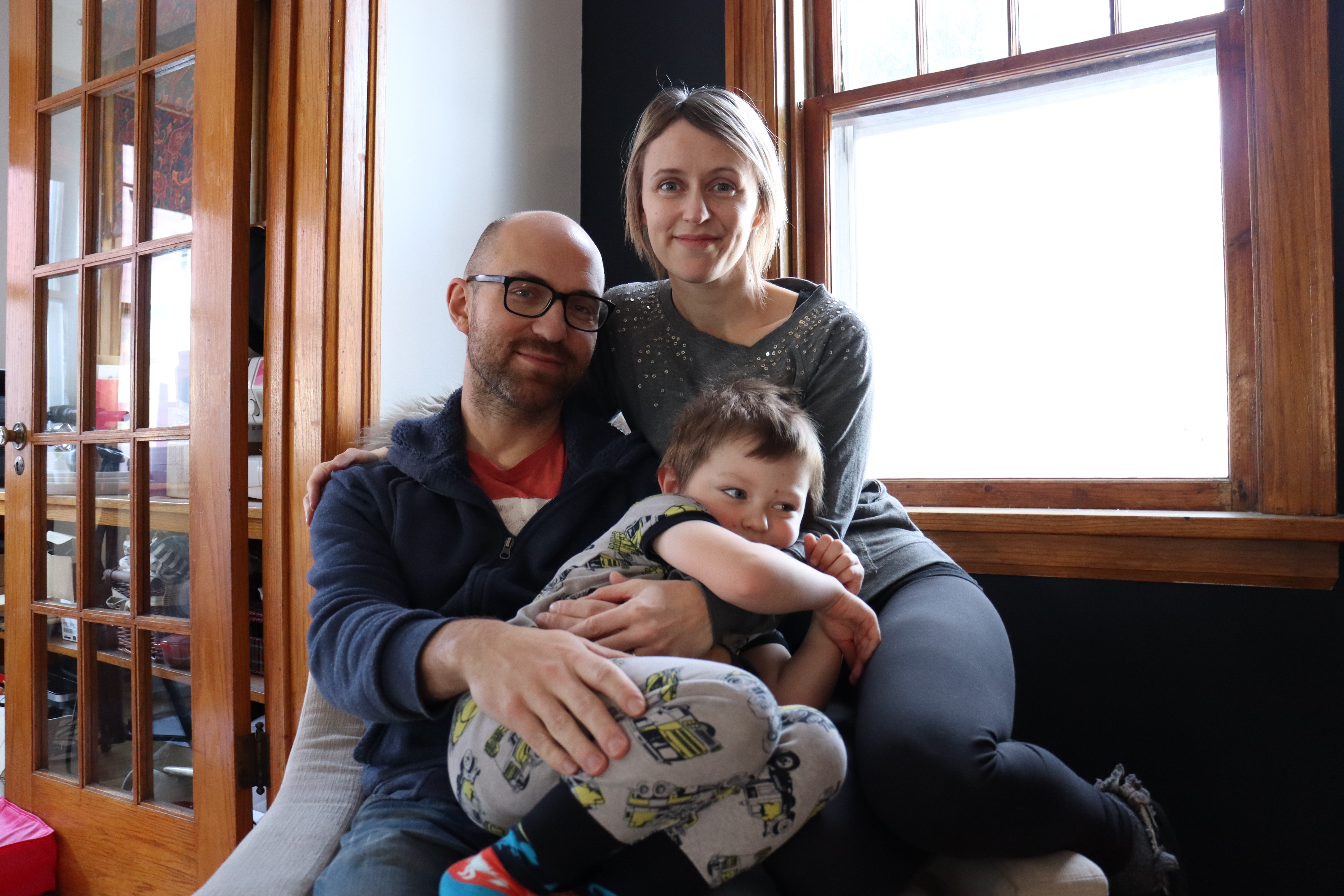 Jeremy and Jessica Penner sit with their four year old on their lap