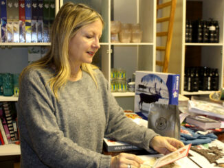Kim Winsor, owner and operator of Johnny Ruth holds a Christmas card in the store's back end. She says her shop is loves to do fun and creative cards for the season.