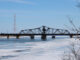 single lane bridge spans narrow channel on a bright winter day
