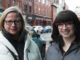 two women are smiling as they are standing in the streets in St. John's