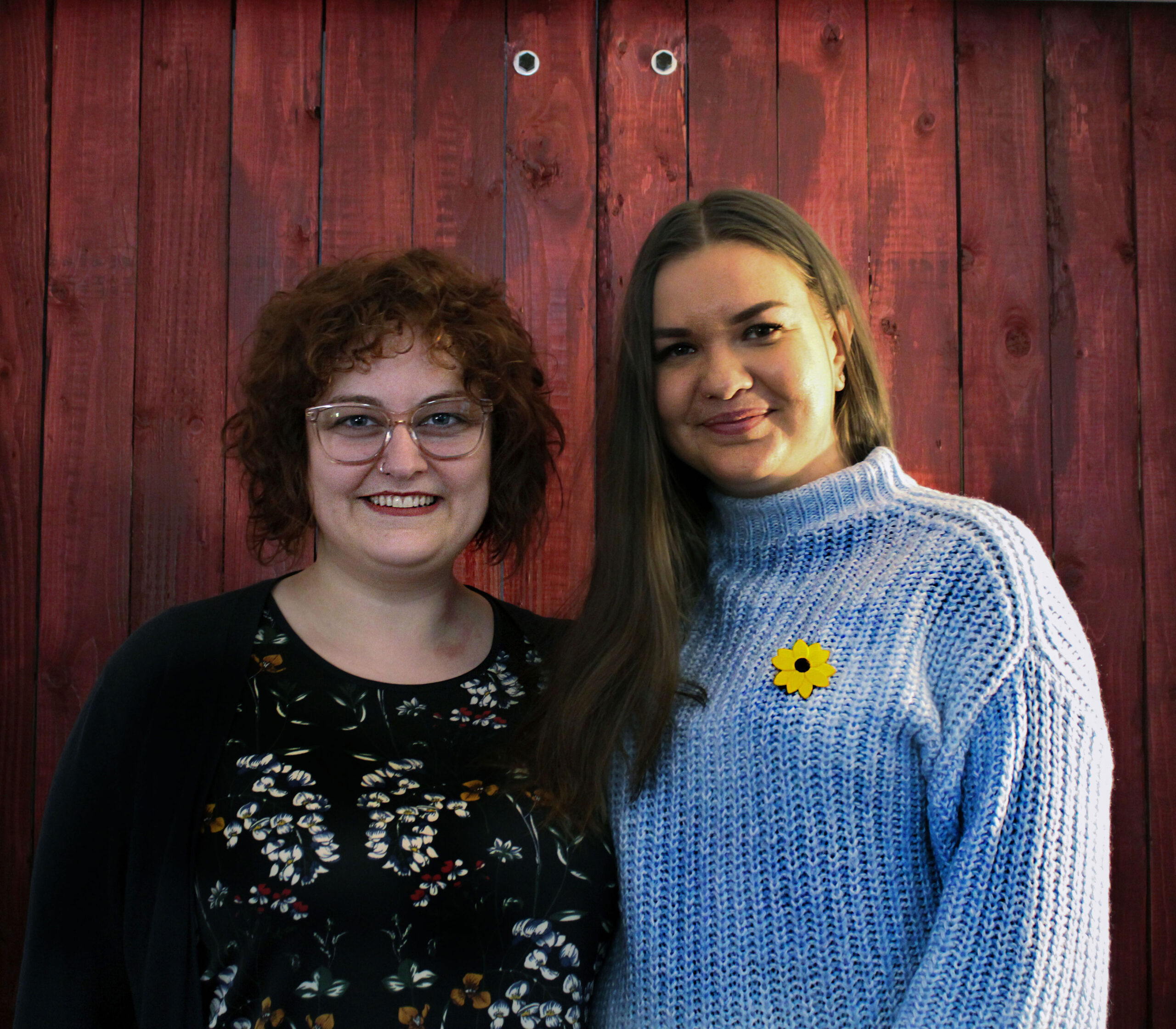 Brought together by their love for Ukrainian music, Maria Cherwick(violinist) in black floral top and Alla Melnychuk (Ukrainian pianist) in blue top with a sunflower batch on her shirt stand infront of a brown door in Halliday studio as they prepare for their upcoming concert. 