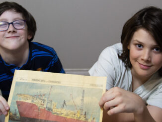Ryatt (left) and Rhys (right) hold up an image of the Terra Nova FPSO boat that their dad works on.