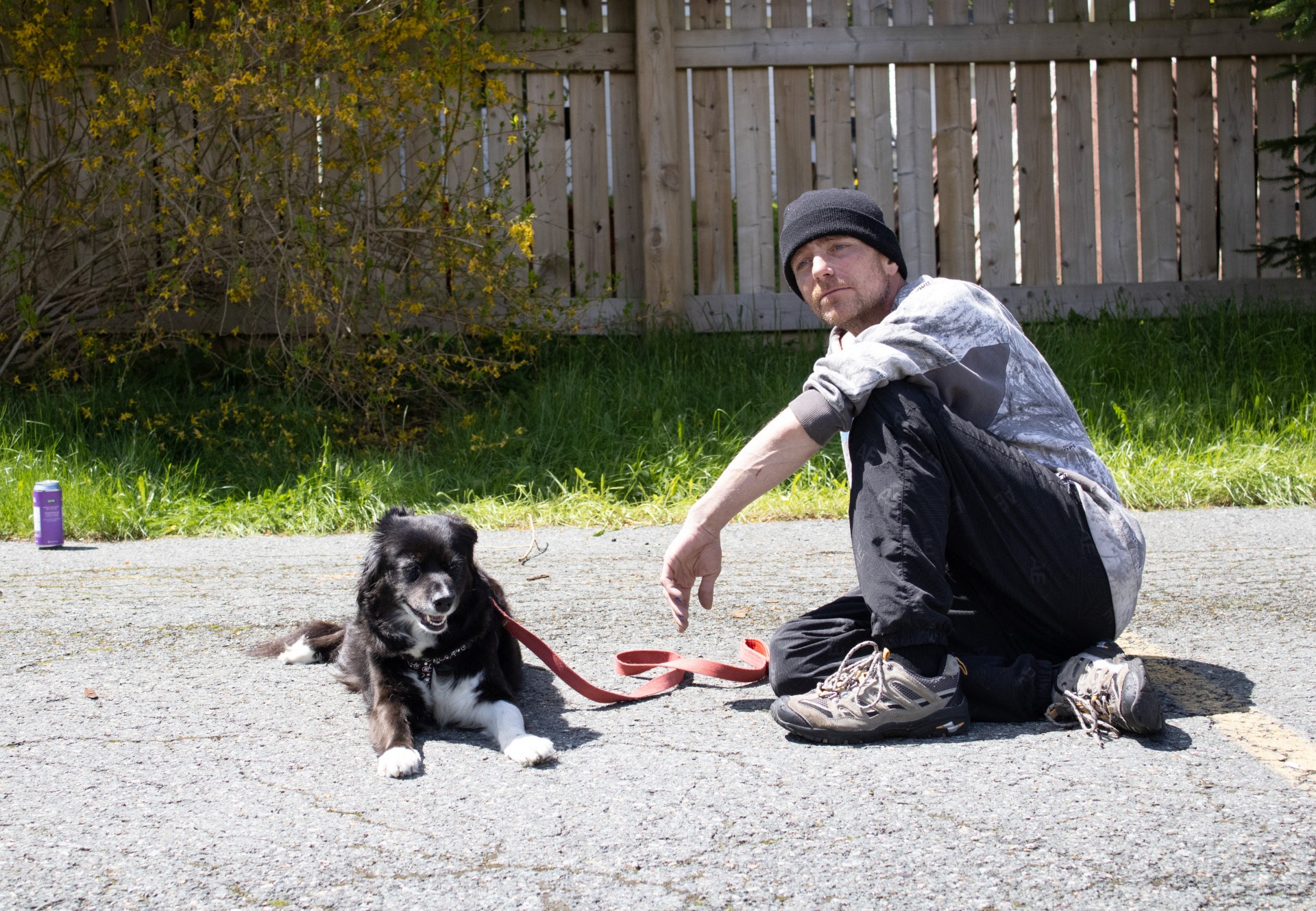 Gregory McCain and his dog Maggie sit on a parking lot outside a shelter. McCain was one of the protesters who occupied a homeless encampment on the Colonial Building property for several months.