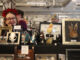 Image shows curious Collections owner, Krista Elliott posed by her stand at the market