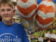 Myles Hunt stands next to his balloons on the day he received his wish,