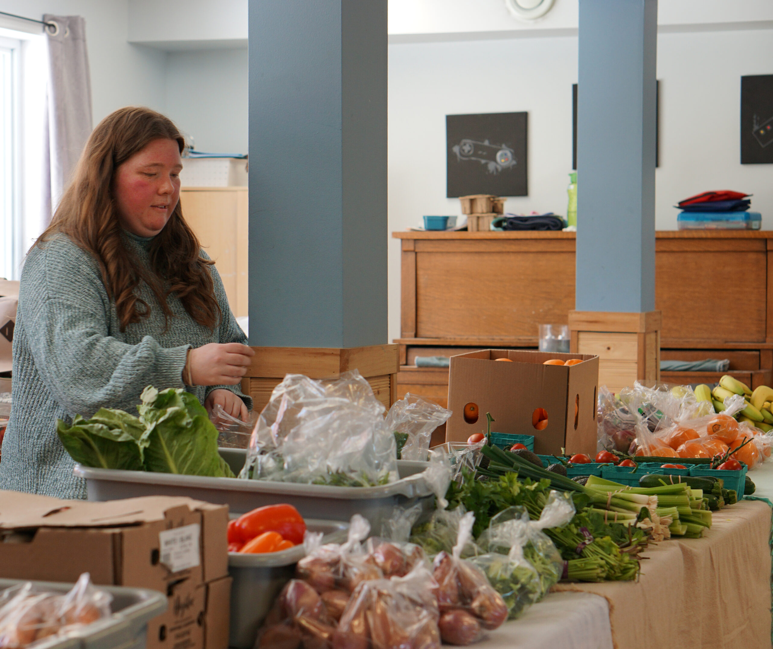 Leah Vatcher prepares the Food On The Move produce stand at the Froude Avenue community center. Noah Johnston / Kicker