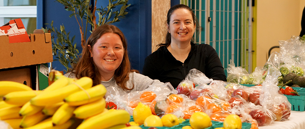 Leah Vatcher and Charlotte Leese sit at the Food On The Move pop-up at College of the North Atlantic's Prince Phillip Drive campus.