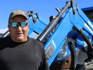 Tom Williams stands in front of his tractor