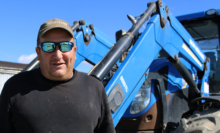 Tom Williams stands in front of his tractor