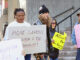 A group of protesters hold signs demanding better snow clearing outside St. John's city hall on Tuesday.